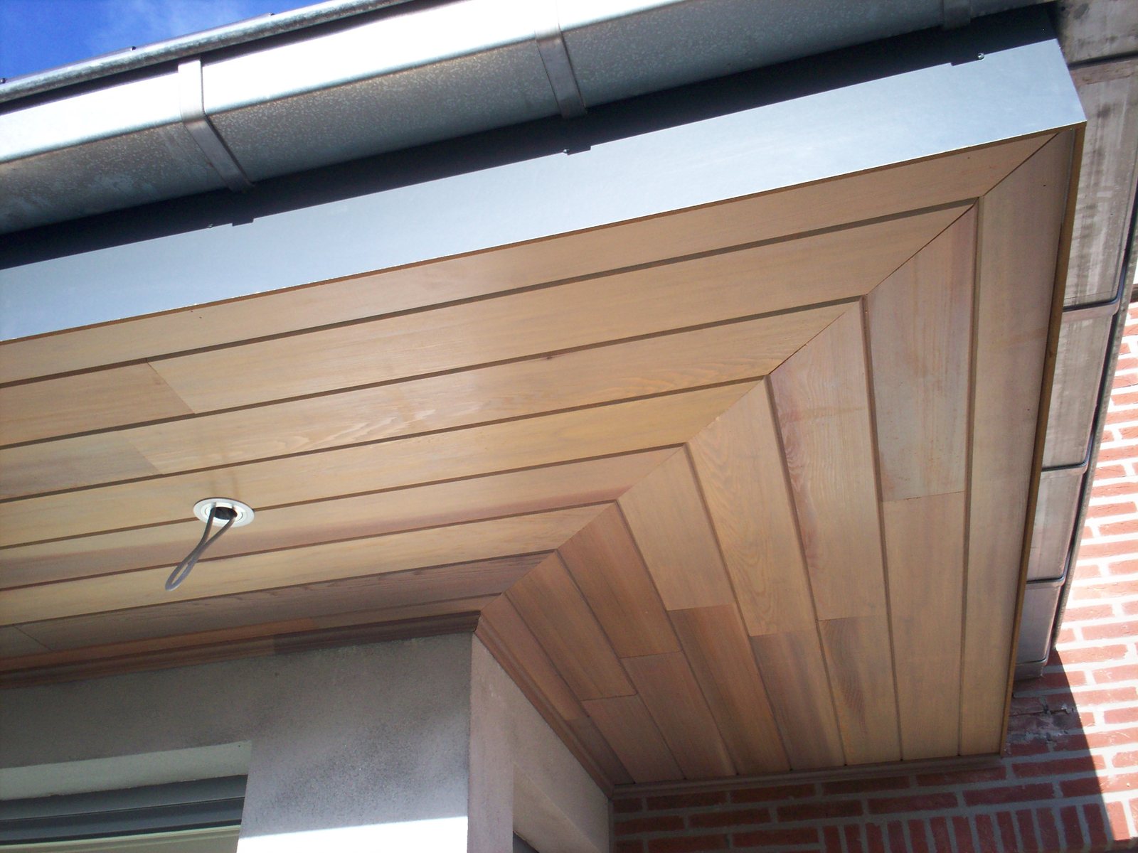 Houten gootbekleding onder een zinken dakgoot