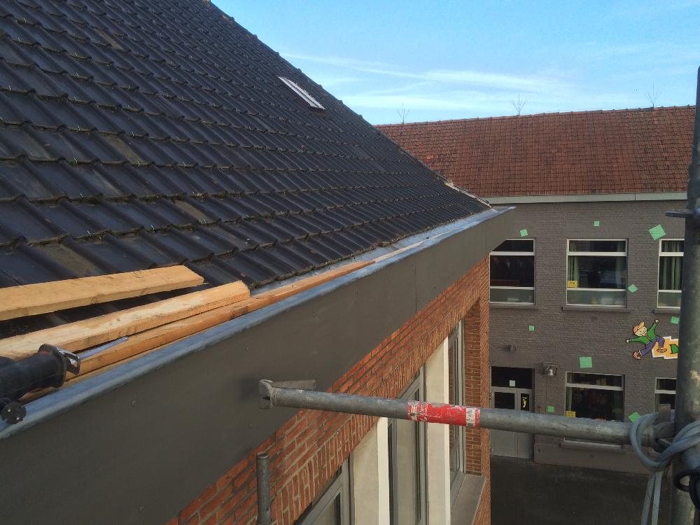 Zinken dakrand en goot op een dak met zwarte pannen